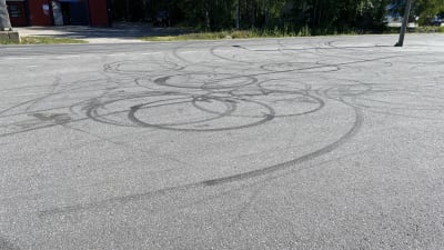 I asfalten ses flera runda och mörka ringar efter att någon har slirat med moped.