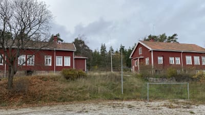 Röda stugor står på en sluttning.