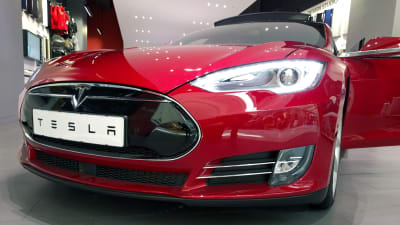En röd Tesla-bil sedd framifrån.