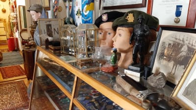 dockor iklädda militära kläder och hyllor fulla av medaljer bakom glas