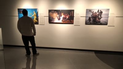 Man framför tre fotografier av Pulitzerkvalitet på Newseum