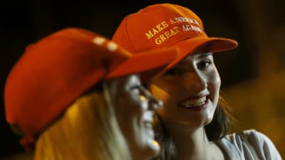 Kvinnor i Singapore bär hattar med Trumps kampanjslogan "Make America Great Again" inför presidentens möte med Kim Jong-un. 