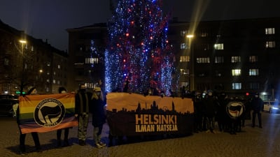 Bild på personer på Tölö torg där personer håller skyltar med antifacistiska budskap.