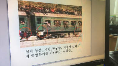 OH ji-Hyun visar bilder på ett överfyllt nordkoreanskt tåg på en dataskärm.