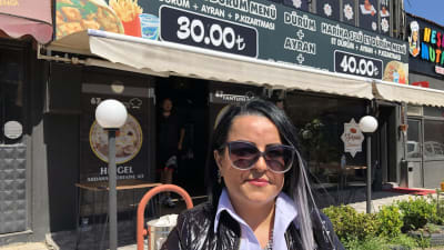 En kvinna står framför en restaurang.