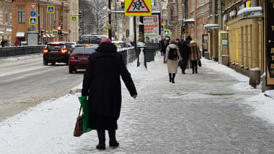 Fotgängare går på trottoar i Sankt Petersburg.