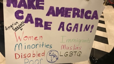 Den handskrivna skylten säger att Amerika respekterar bland annat kvinnor och fattiga.