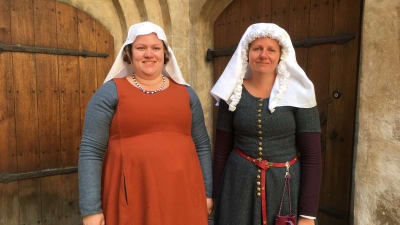 två kvinnor är utklädda i medeltidsdräkter. 