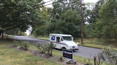 En postibi. kör förbi en Trumpskylt i New Jersey i USA: