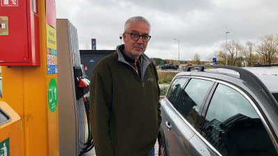 Esa Lapela står bredvid sin bil vid en bensinstation i Pargas