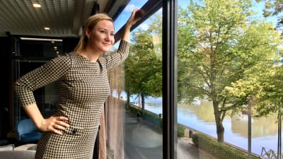 Minja Westerlund tittar ut ur ett fönster.