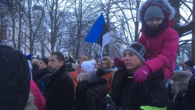 Människor som samlats för att se flagghissningen och sjunga Estlands nationalsång. 