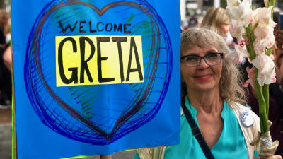 Katherine med ett plakat med texten "Welcome Greta".