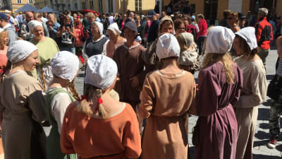 Folk står i en samling under medeltida marknaden i Åbo. 