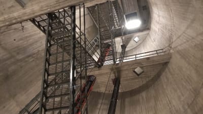 Metalltrappor går sick-sack över bilden uppåt mellan de grå betongväggarna.