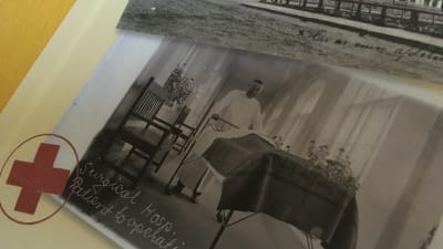 Ett bokomslag med en svartvit bild på en sjukhuskorridor där en läkare skuffar en järnsäng.