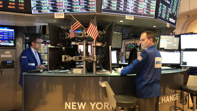 Två aktiemäklare har dekorerat sin runda desk med amerikanska flaggor, vid börsen i New York.