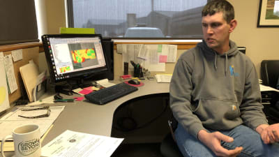 Lowell Neitzel vid sin dator, med färggrann odlingsplan på skärmen.