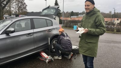 Nicklas Hägen dricker kaffe invid sin bil.