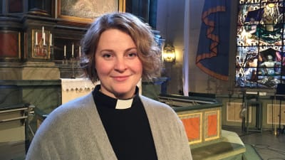 Kyrkoherde Mia Anderssén-Löf framme vid altaret i Nykarleby kyrka.
