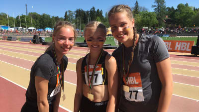 Tre flickor från S:t Olofsskolan med medaljer runt halsen under Stafettkarnevalen.