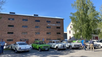 Veteranbilar parkerade framför bilmuseum.
