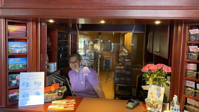 Kvinna ler i hotellreception.