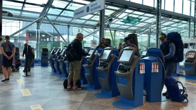 Människor vid en checkin-automat.