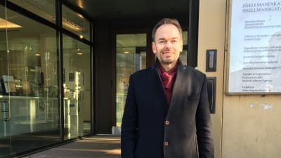 Man vid ingång till kontorshus i Helsingfors