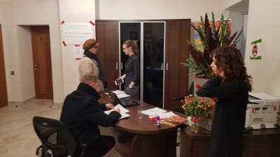 Personer står och diskuterar i Ksenia Sobtjacks valbyrå.