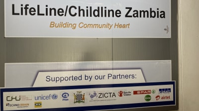 En skylt med texten "LifeLine/Chuldline Zambua - Building Community Heart.