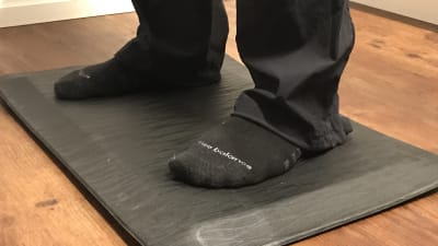fötter på en ergonomisk matta