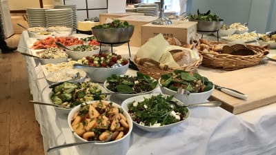 Ett uppdukat buffébord med sallader och bröd.