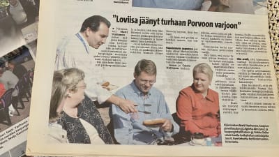 Tidningsurklipp med en bild där en yngre José Fuentes serverar berlinermunk åt Matti Vanhanen. Vid sidan av honom sitter två kvinnor och bildtexten berättar att det är tidigare kommunpolitikerna Agneta Alm och Sirkku Zeller.