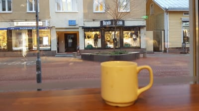 Kaffekopp i caféförnster mot gata