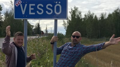 Micke Björklund och Matias Jungar vid en vägskylt som det står Vessö på.