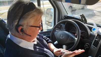 Kvinnlig busschaufför torkar händerna med servetter.