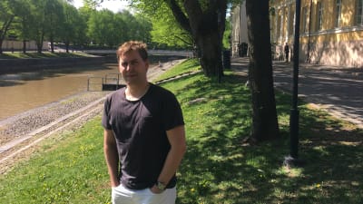 Jonas Lagerström står vid åstranden i Åbo en solig sommardag.