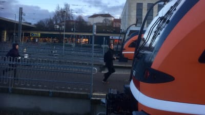 Två personer springer till tåget på Balti jaam, Tallinns järnvägsstation.