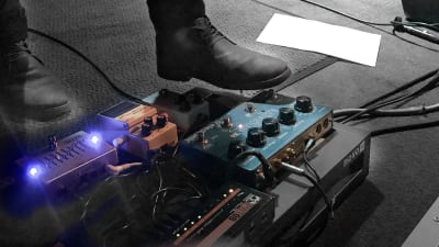 Fot som trycker på effektpedaler för elgitarr på pastis konsert 2019.