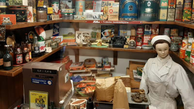 litet butikmuseum med docka föreställande ett butiksbiträde omgivet av butiksinredning och förpackningar