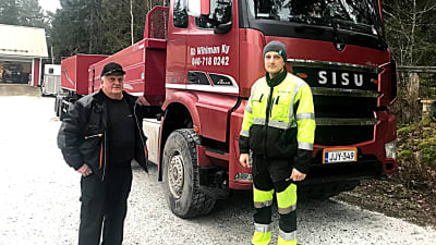 Två män framför en långtradare.