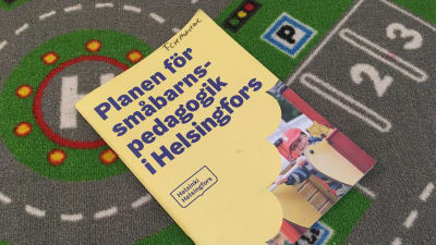 En häftad plan för småbarnspedagogik på en bilmatta.