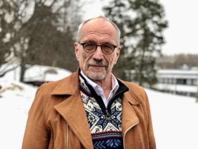 Nils Torvalds med skog och snö i bakgrunden