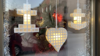 Symbolerna för tro, hopp och kärlek i ett fönster.