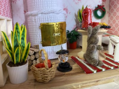 Ett litet hem i miniatyr, med en kakelugn, kanin och inredning
