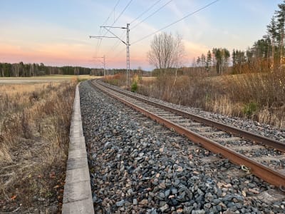 En enkelspårig järnväg i solnedgången.