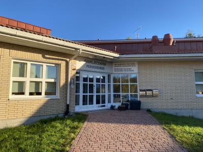 En dörr i ett tegelhus med en skylt där det står familjecenter.