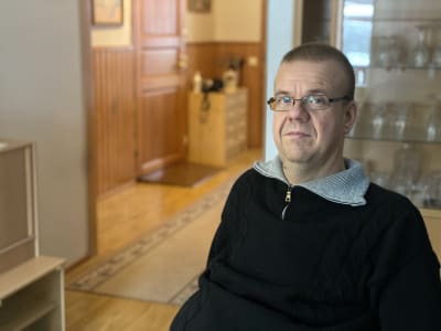 Man med glasögon och svart tröja.