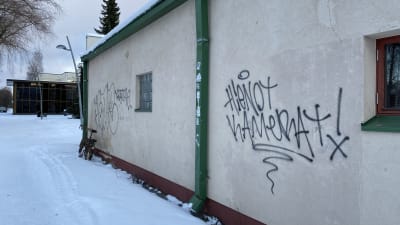 Sprayad text på en vägg. Texten på finska lyder hienot kamerat, vilket kan översättas till fina kameror.